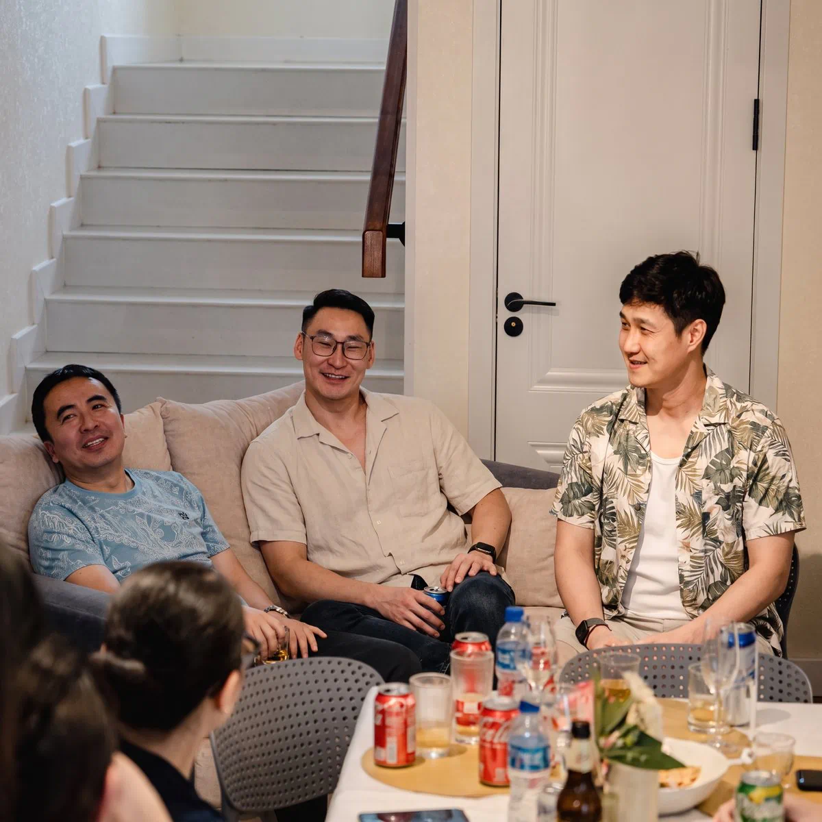 几位男士在舒适的客厅里坐在沙发上聊天